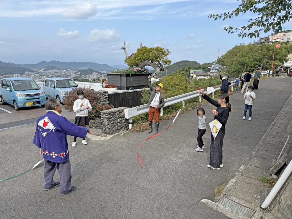 子供と大人が一緒になって自作の凧を上げている